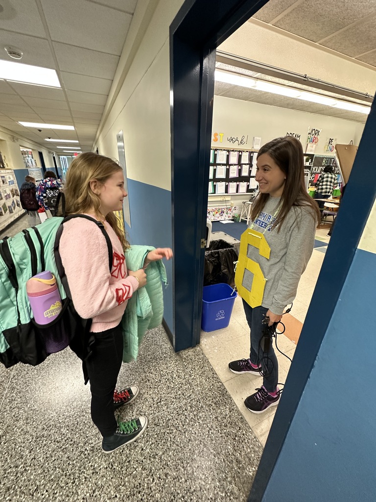 A student is surprised by her teacher wearing a "6" to celebrate the 67th day of school.