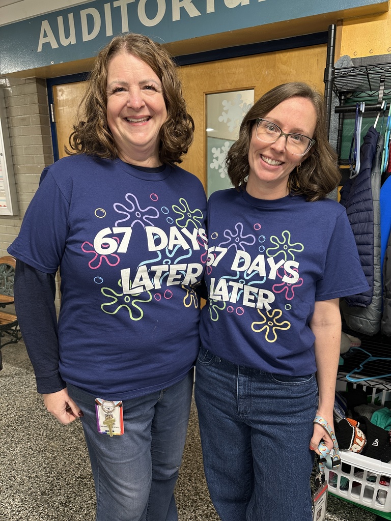 Two staff members show off their t-shirts to celebrate the 67th day of school.