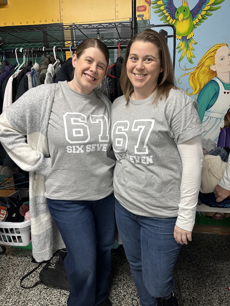 Two staff members show off their t-shirts to celebrate the 67th day of school.