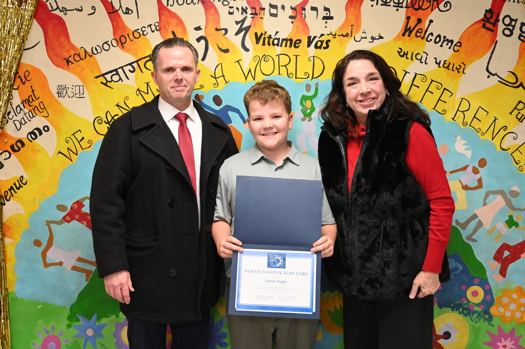 James Nagle poses with his parents while holding his certificate for his Kids Care recognition.