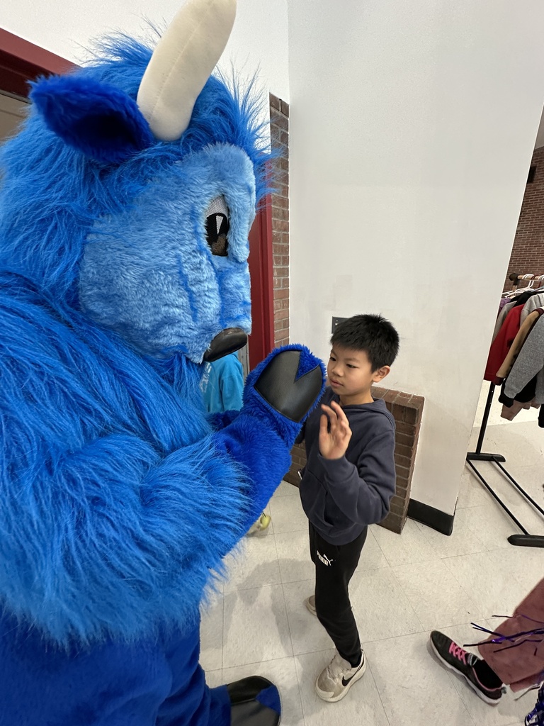 A student high fives the Bison mascot.