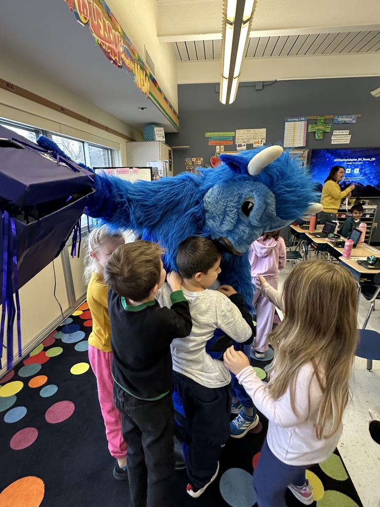 A group of students hug the Bison mascot.