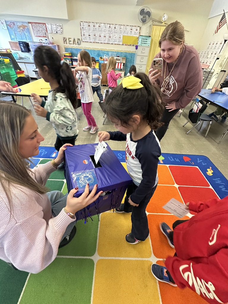 A student places her ballot in the ballot box.
