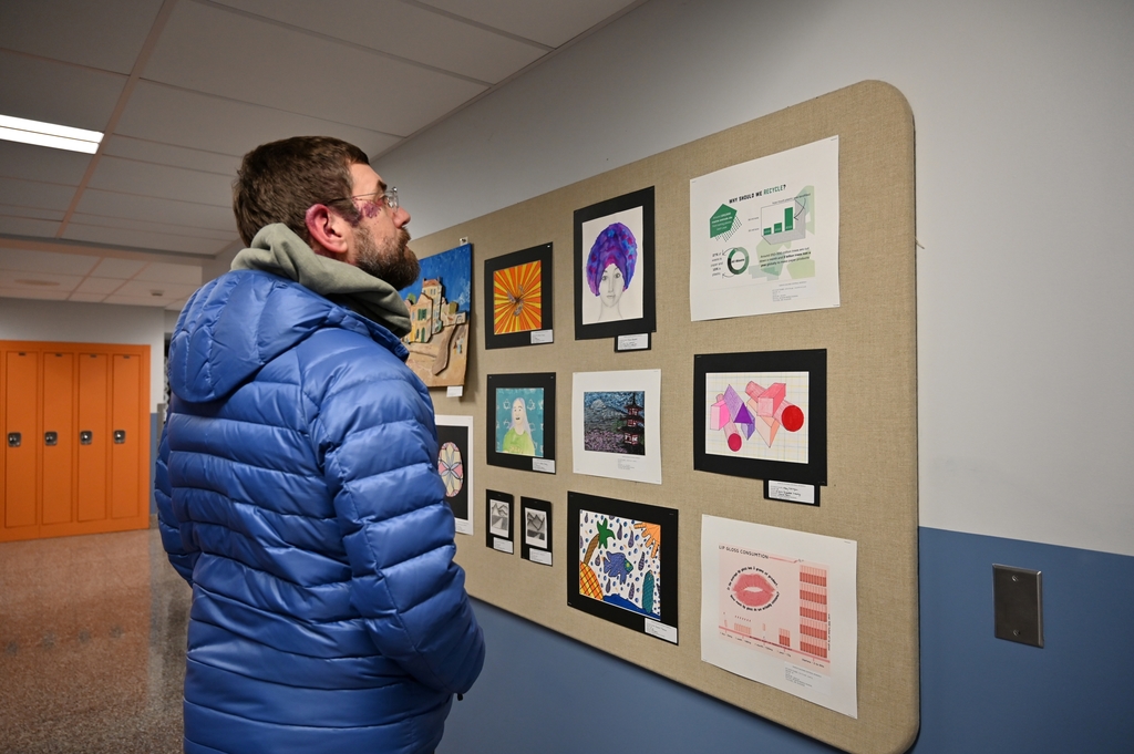 A person takes in works of art in a gallery.