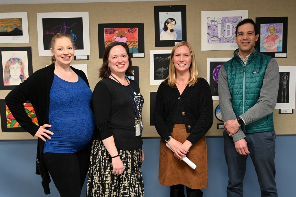 Shaker Middle School art teachers pose for a photograph in front of student artwork.