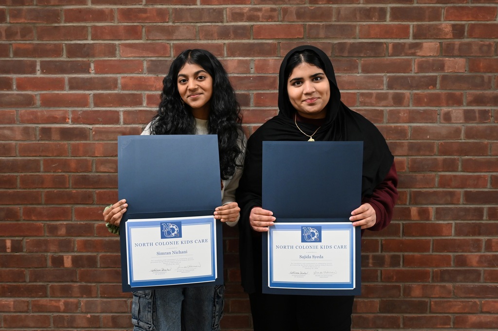 Two students pose with certificates received for North Colonie Kids Care award.