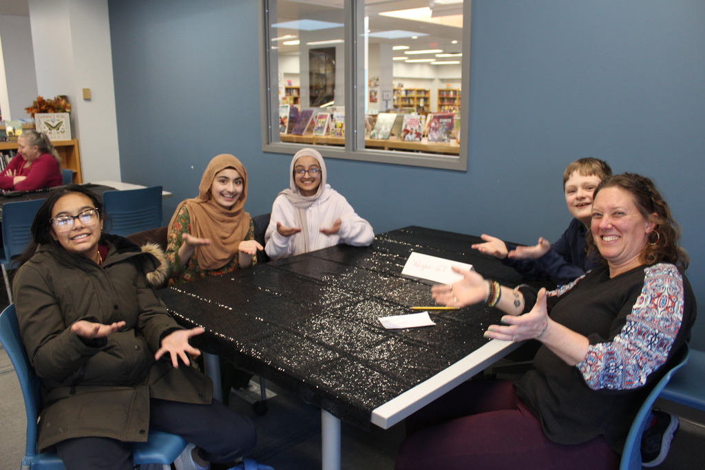 library trivia four students and a teacher giving six seven hand gesture