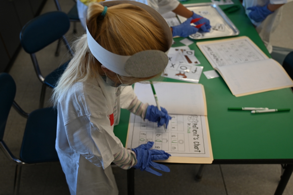 student doctor finding vowels and filling out a chart