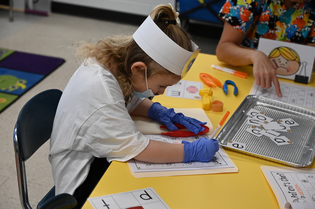 student doctor finding vowels and filling out a chart