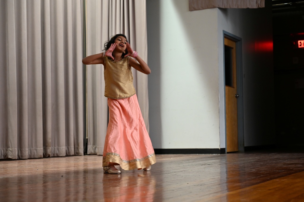 A student performs a dance routine on stage.