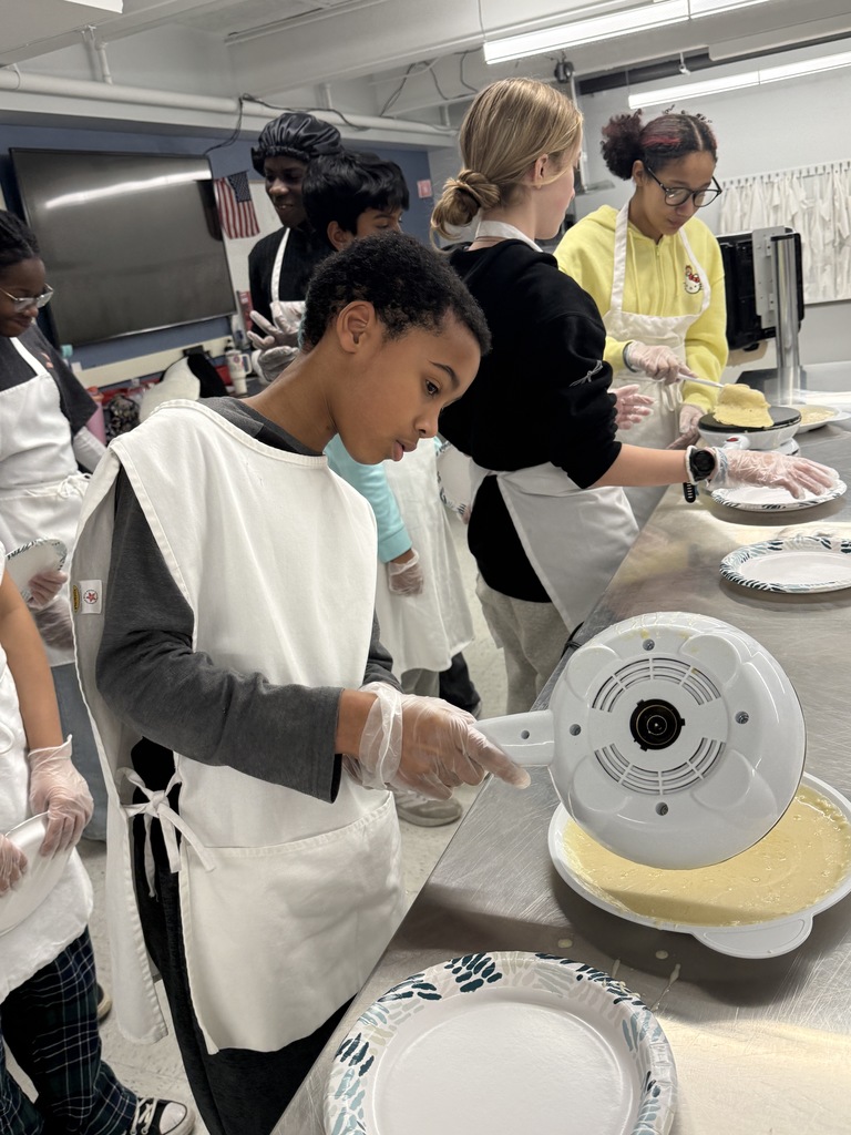 Crepe day at shaker middle school with a student making a crepe and other students watching