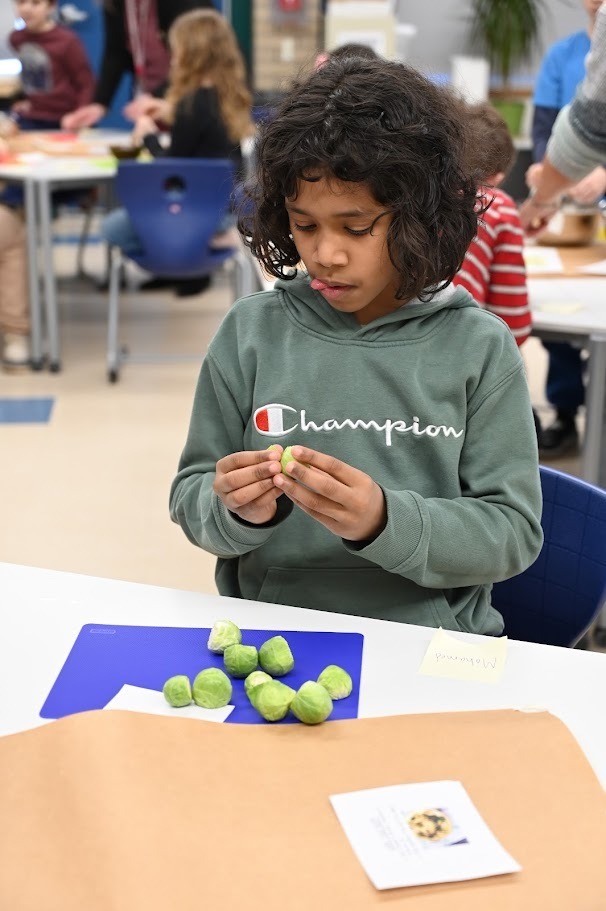 Forts Ferry student prepares brussel sprouts