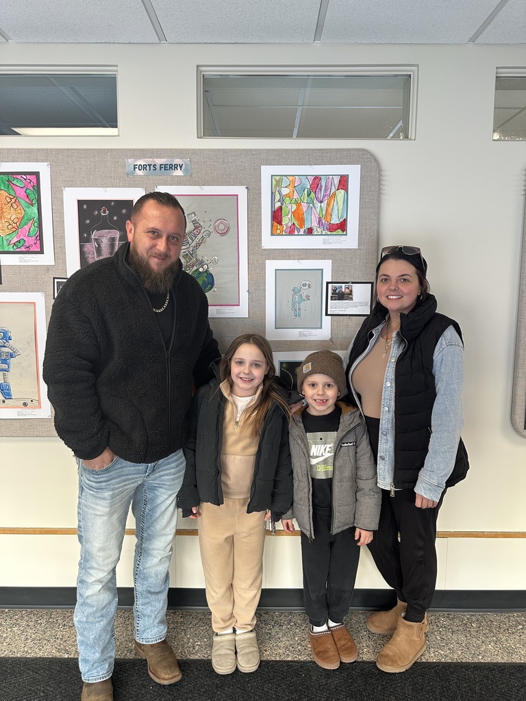 A family poses in front of their student's artwork on display.