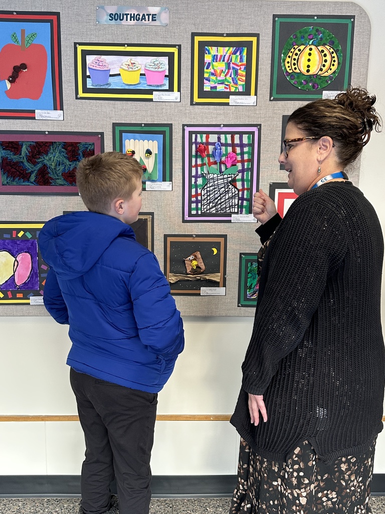 Superintendent Skeals discusses a student's artwork with him.