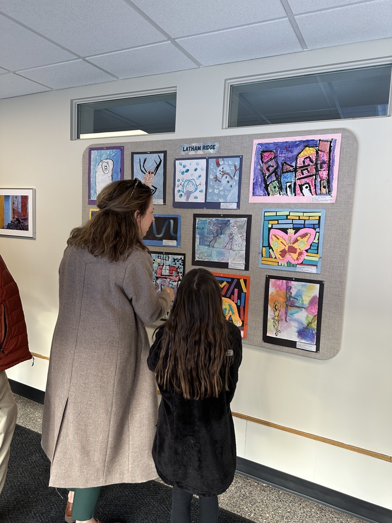 A family looks at artwork hanging in the gallery.