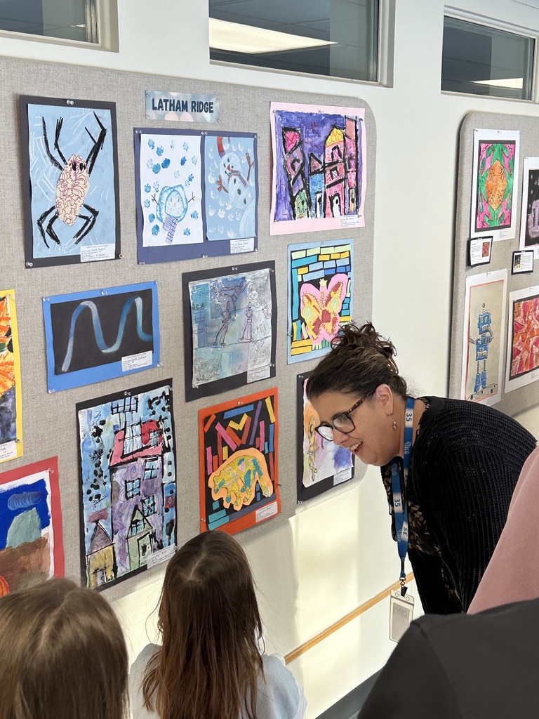 Superintendent Skeals learns more about a student's artwork on display.