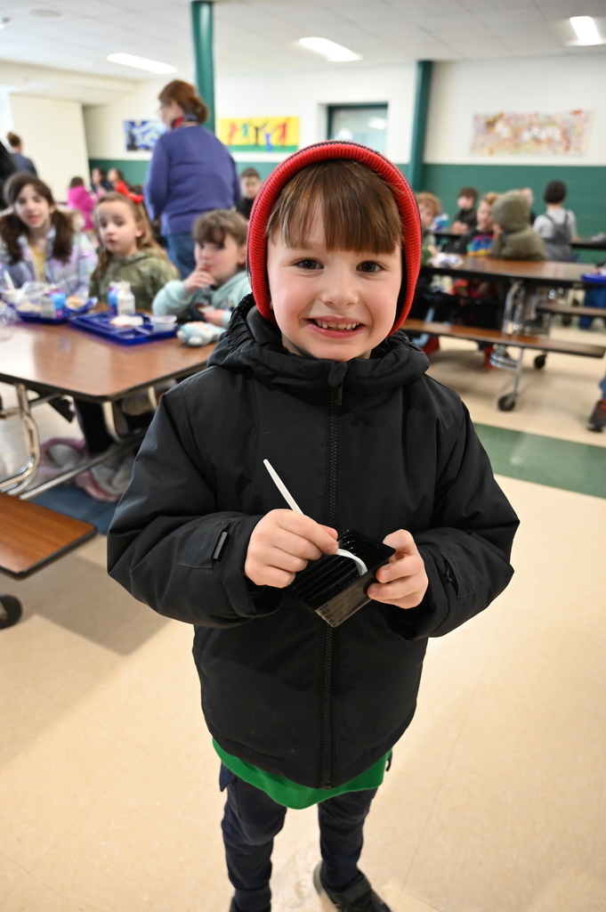 A student smiles with his sample of Brussels sprouts.