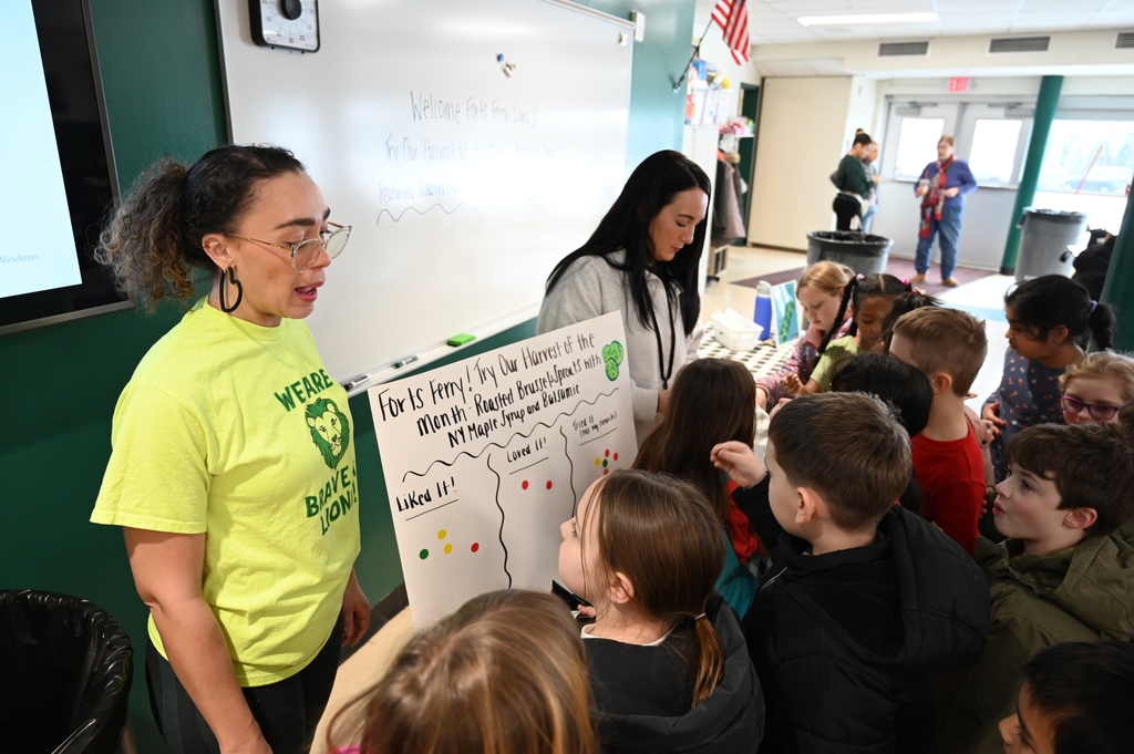 Students place stickers on a posterboard to explain how they felt about the Harvest of the Month sample.