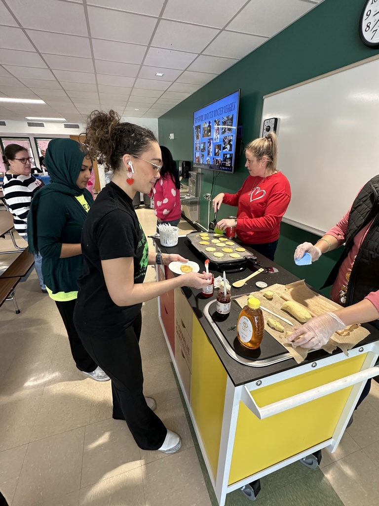 Forts Ferry staff members put jam on their johnnycakes being prepared by their colleagues.