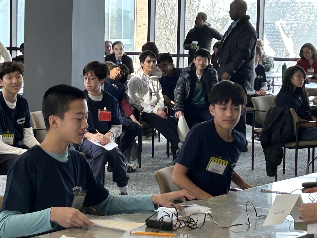 Two students sit at a table and compete at the MathCounts competition.
