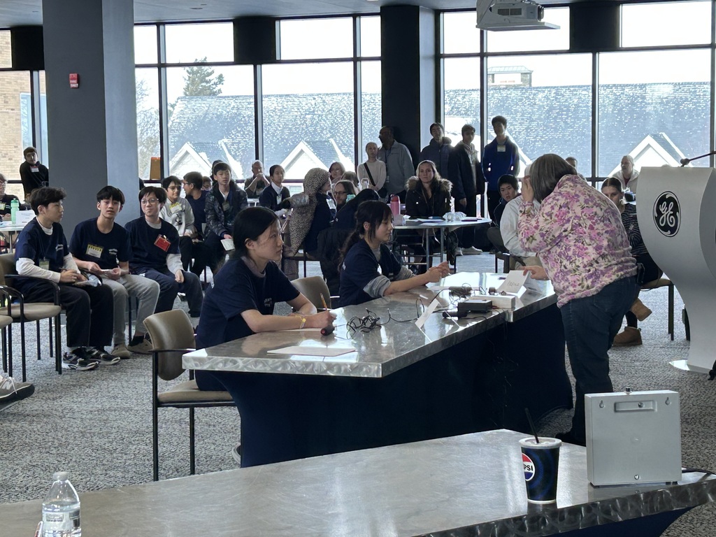 An advisor guides two students competing at the MathCounts competition.