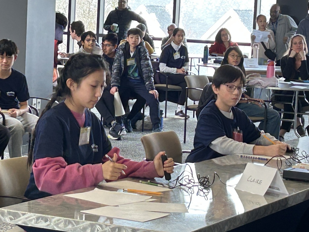 Two students sit at a table and compete at the MathCounts competition.