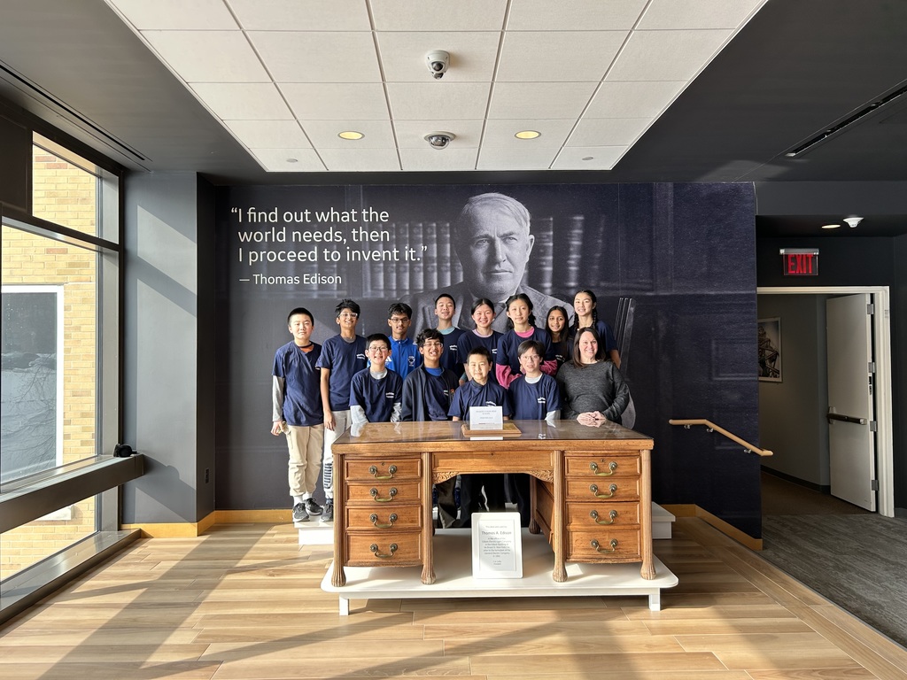The SMS MathCounts competition team poses behind a table with their advisor.