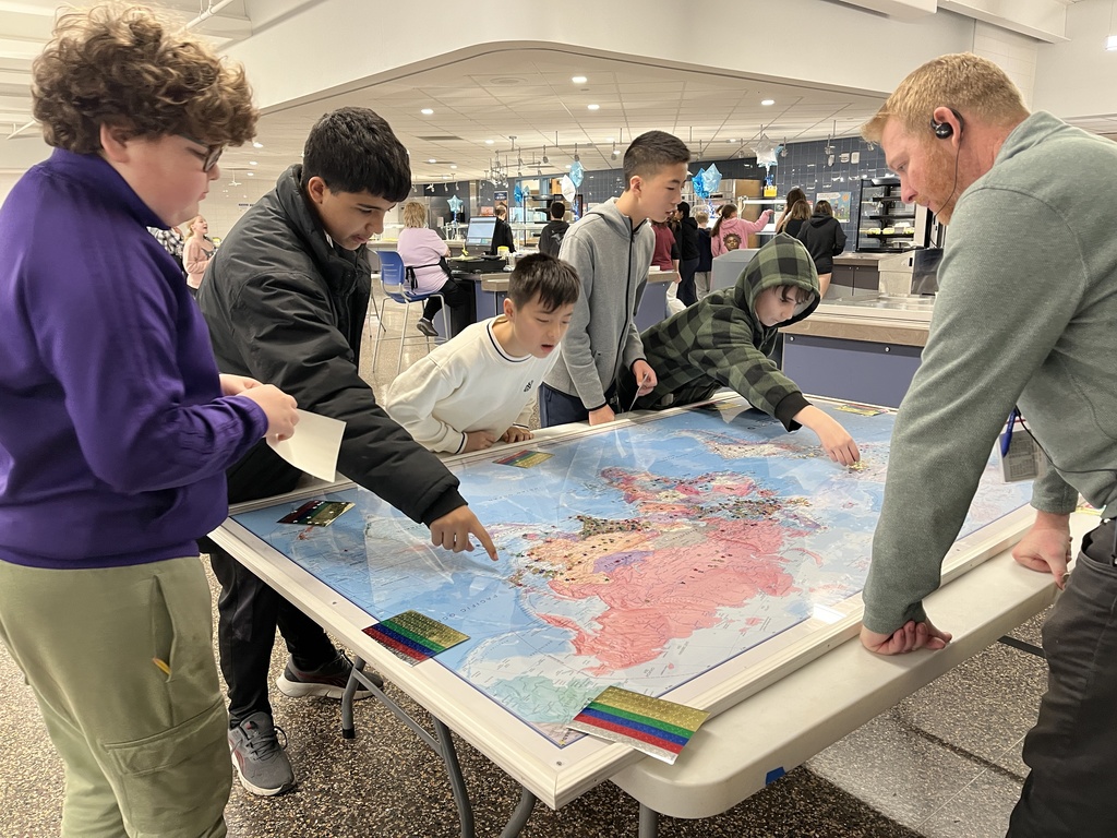 Students placing stars on the globe map
