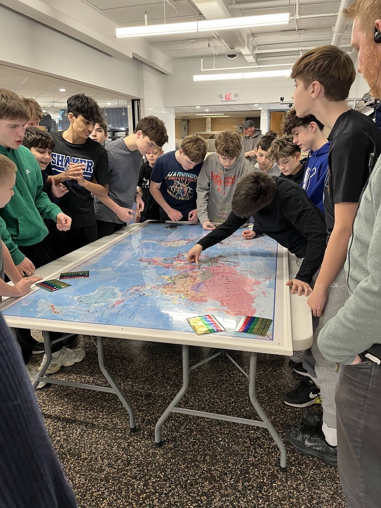 Students placing stars on the globe map