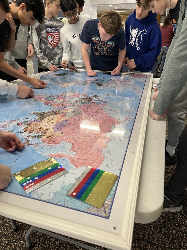 Students placing stars on the globe map
