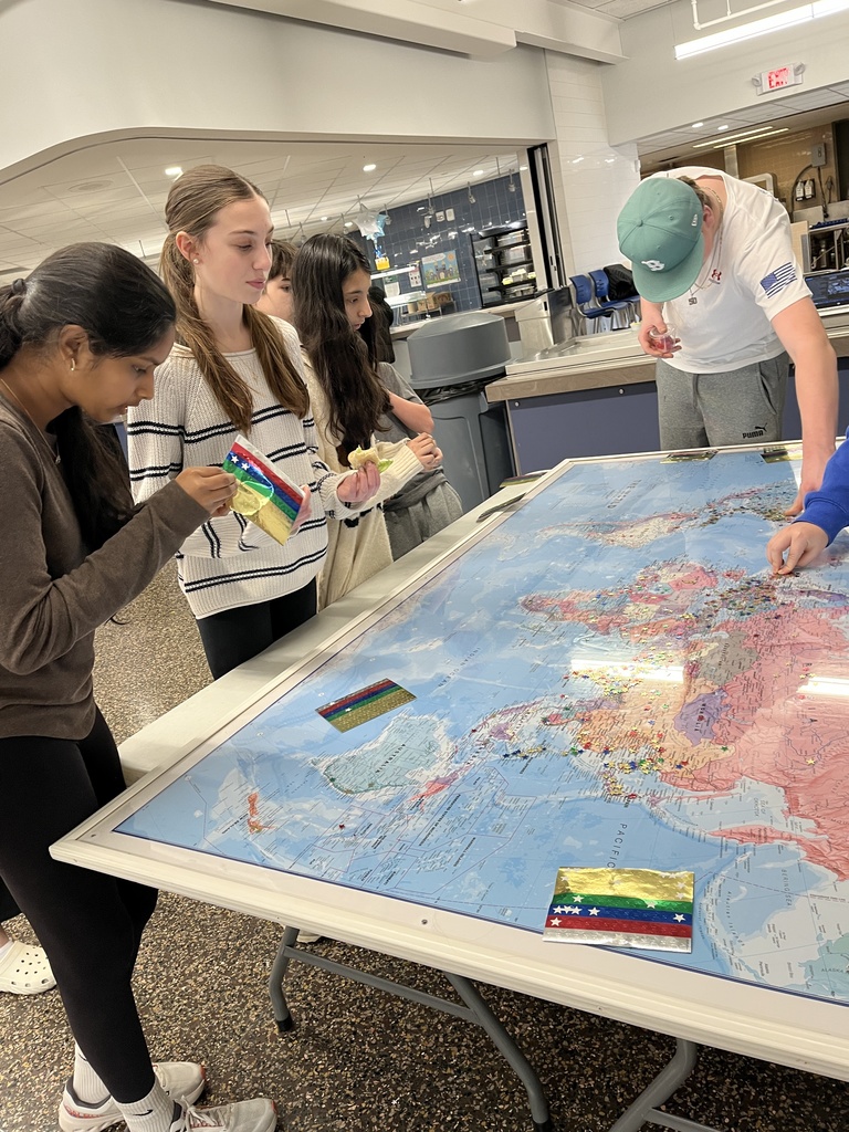 Students placing stars on the globe map
