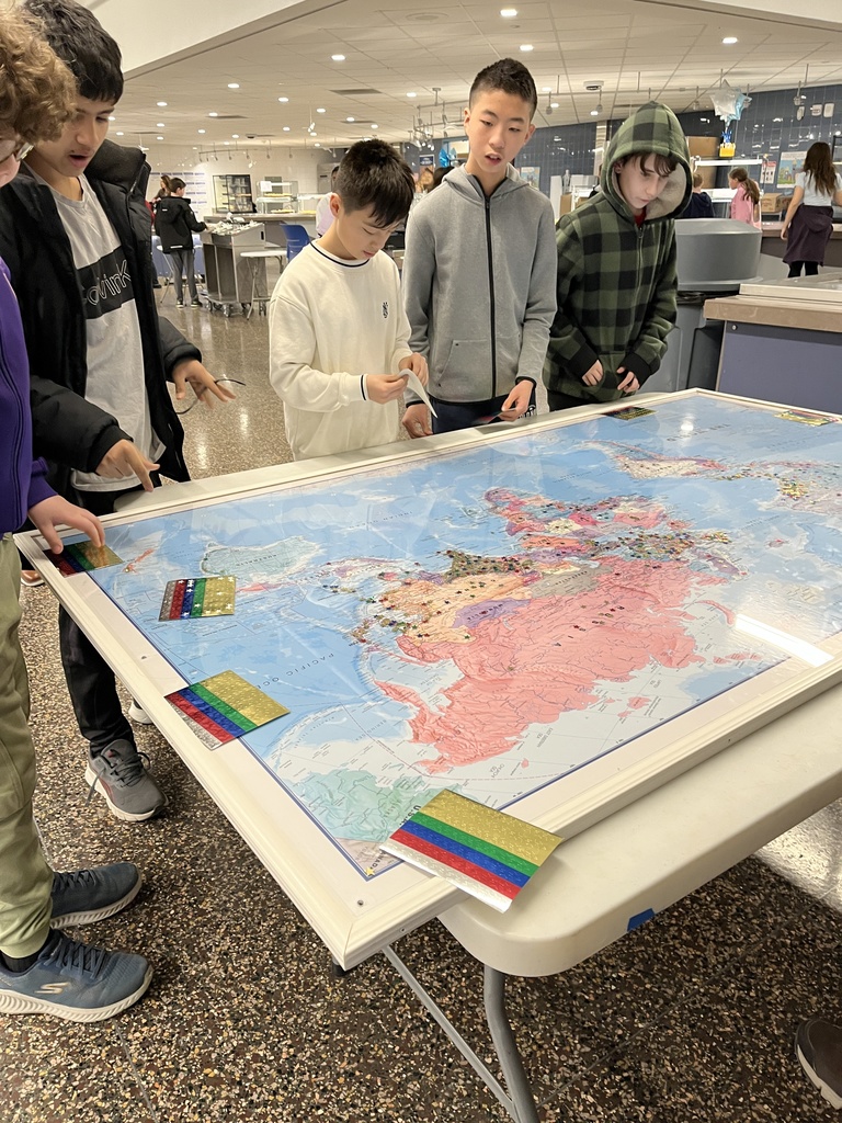 Students placing stars on the globe map