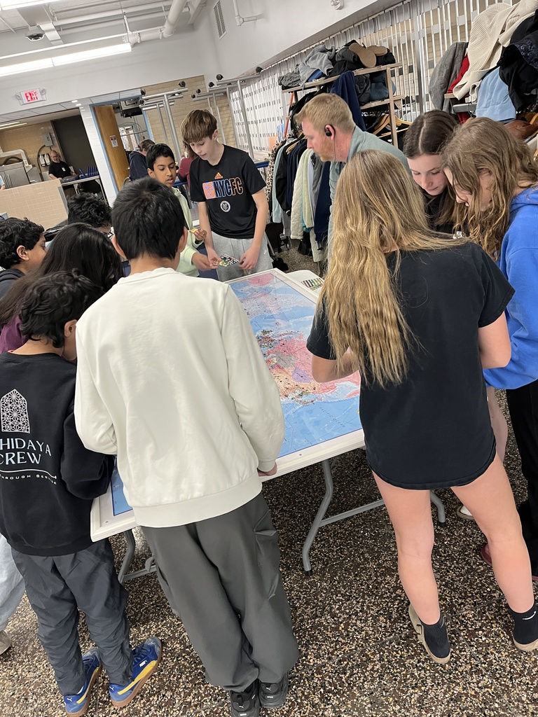 Students placing stars on the globe map