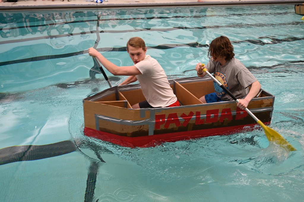 SHS students row across the pool in their boat "The Payload"