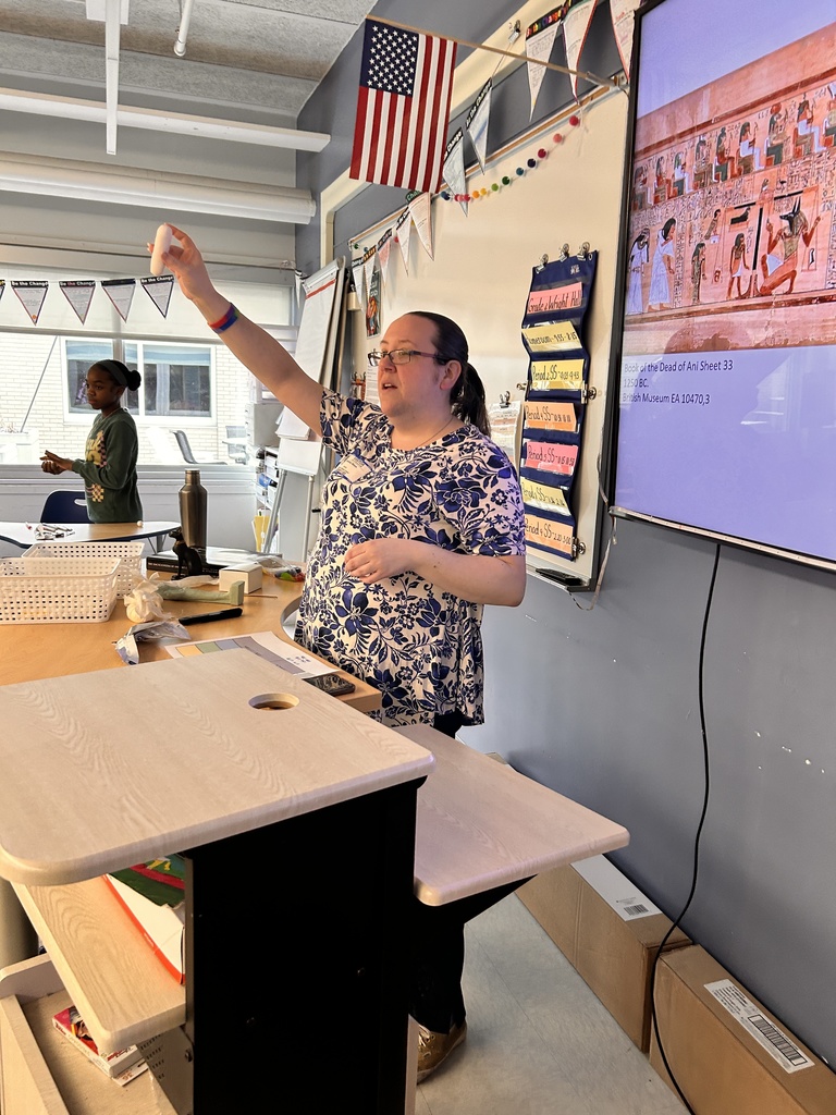 Ms. Moon, from the Albany Institute, shows off a Shabti at the front of a classroom.