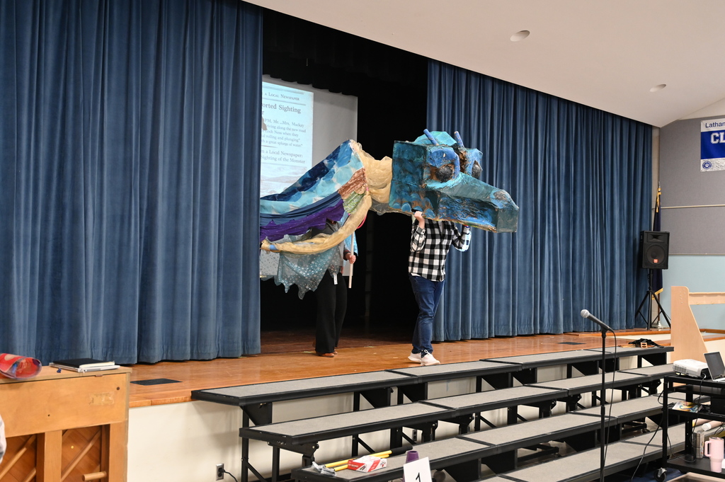 A version of a "water horse" comes out from behind the curtains of the stage.