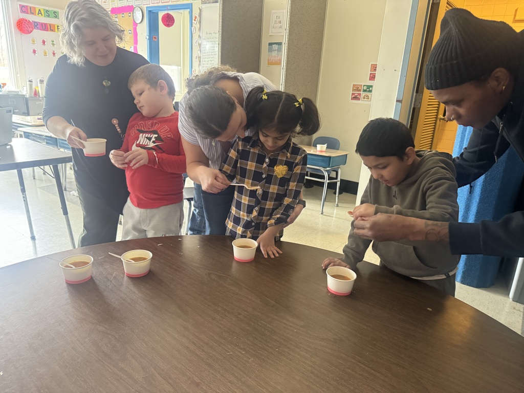 Students taste the soup they made from small cups.