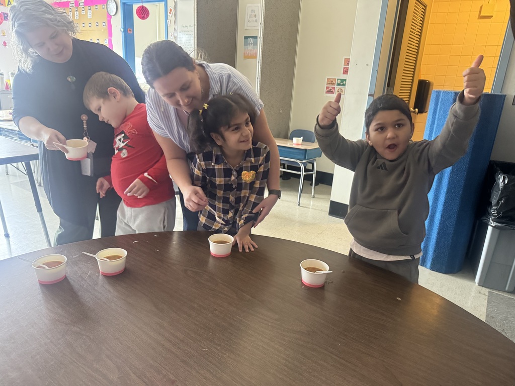 One student smiles and another gives thumbs up after tasting the soup they made.
