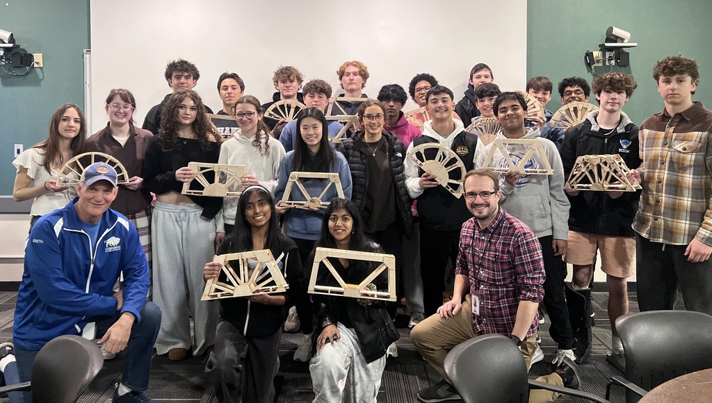 Students holding awards after building some cool bridges