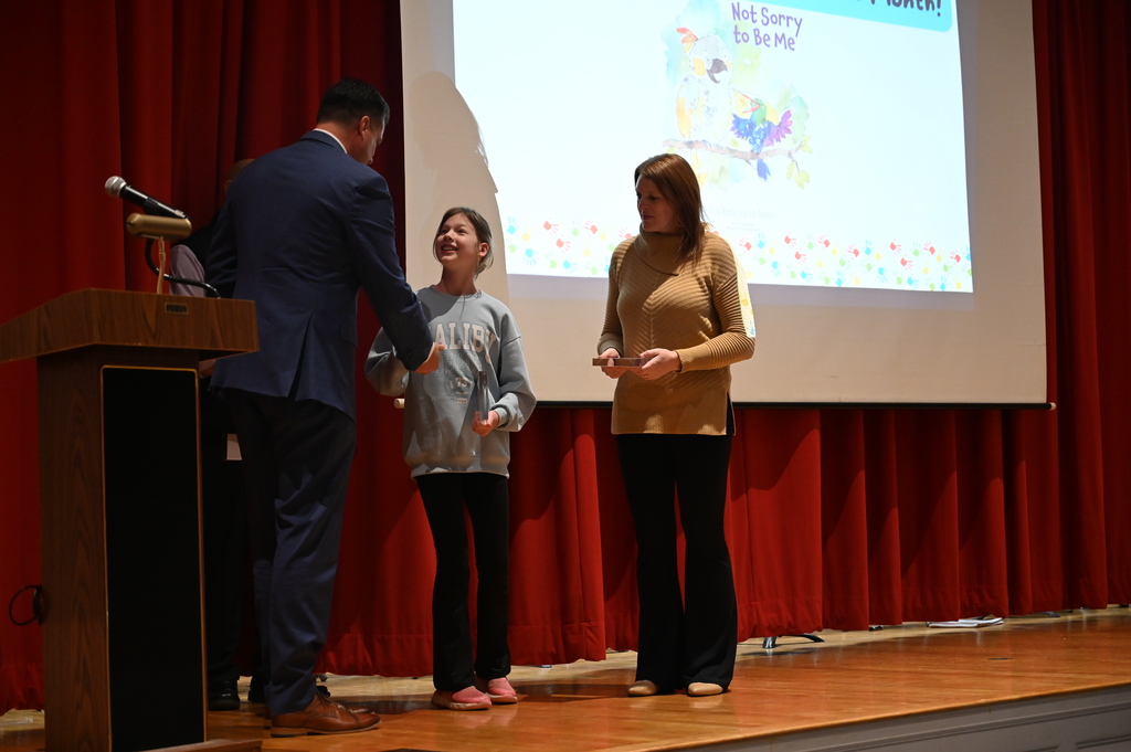 Senator Ashby giving medal to Isla and Vicky