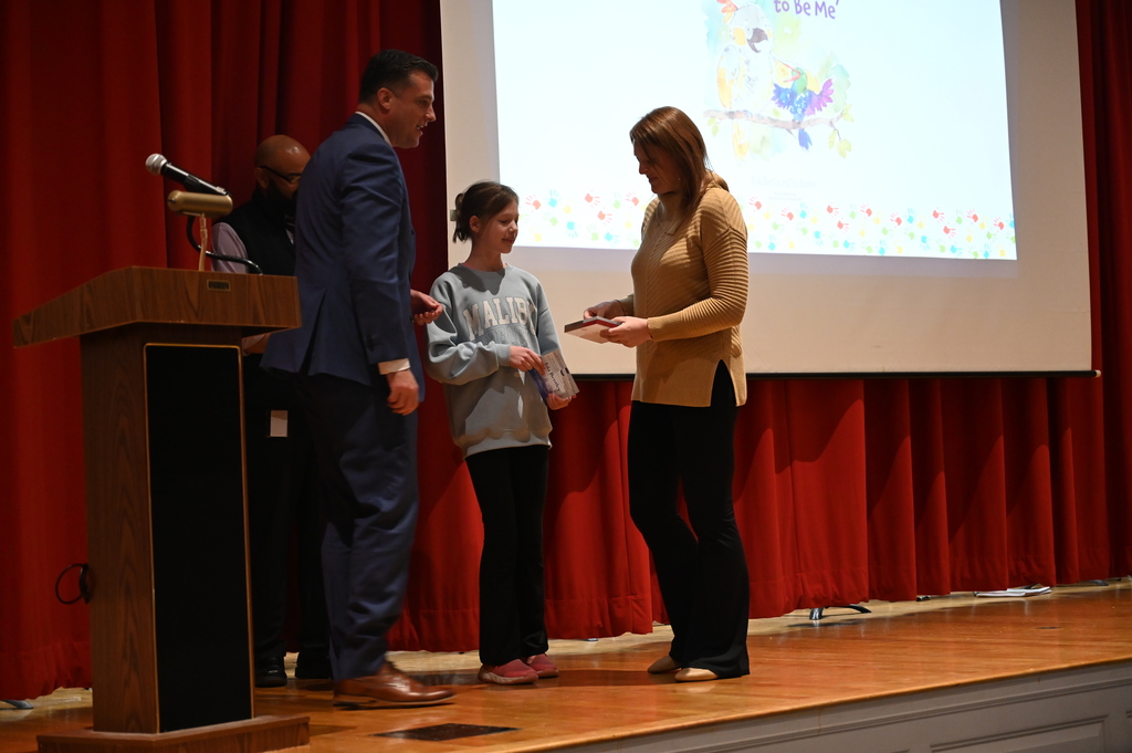 Senator Ashby giving medal to Isla and Vicky