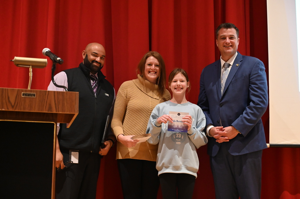 Senator Ashby giving medal to Isla and Vicky