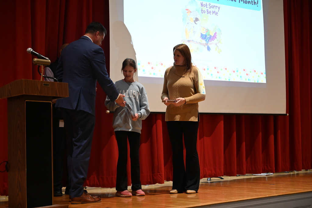 Senator Ashby giving medal to Isla and Vicky