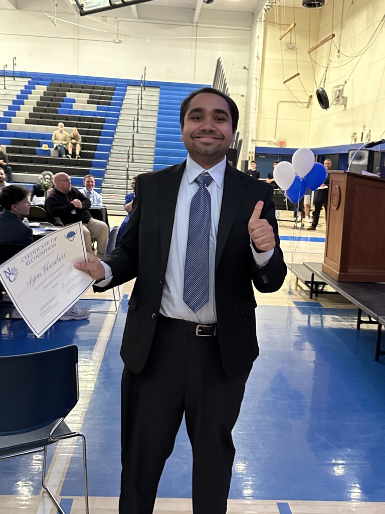 A smiling student gives  a thumbs up after receiving his certificate.