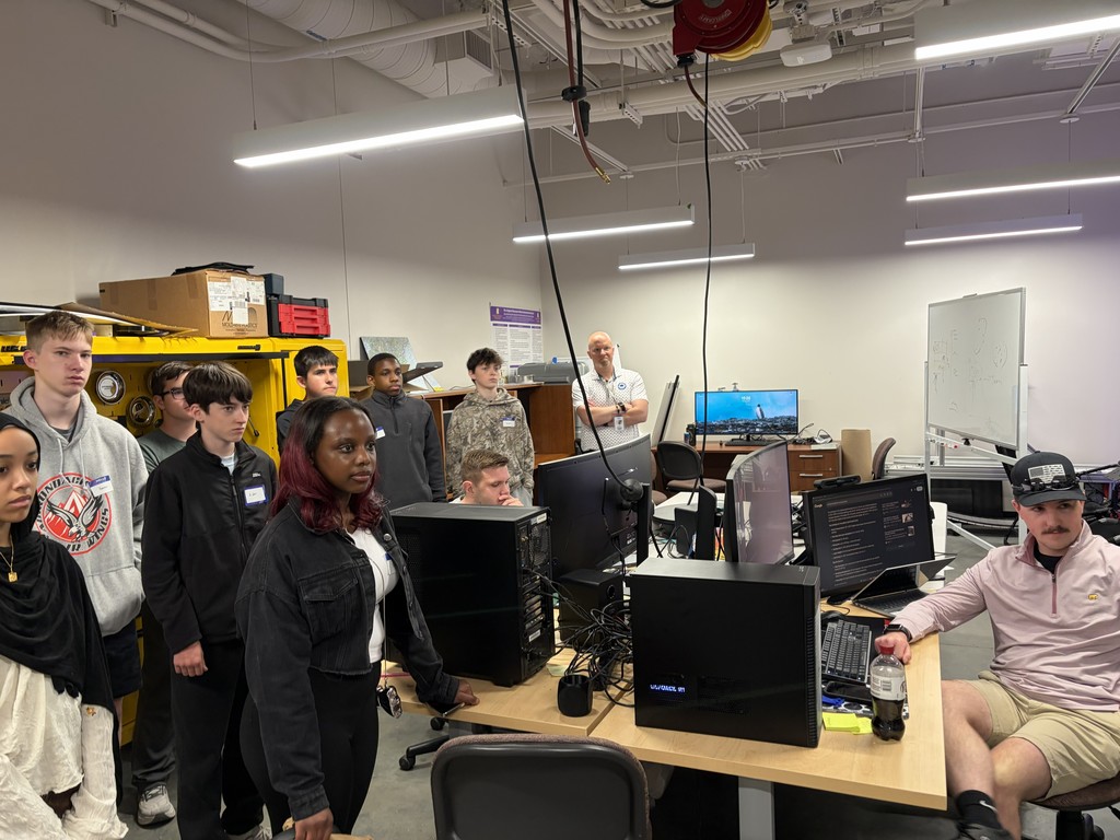 Students stand in a computer/technology classroom at UAlbany.