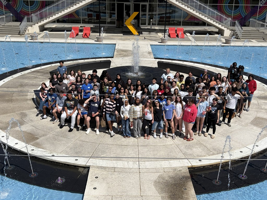 A large group of students pose around a water fountain at UAlbany.