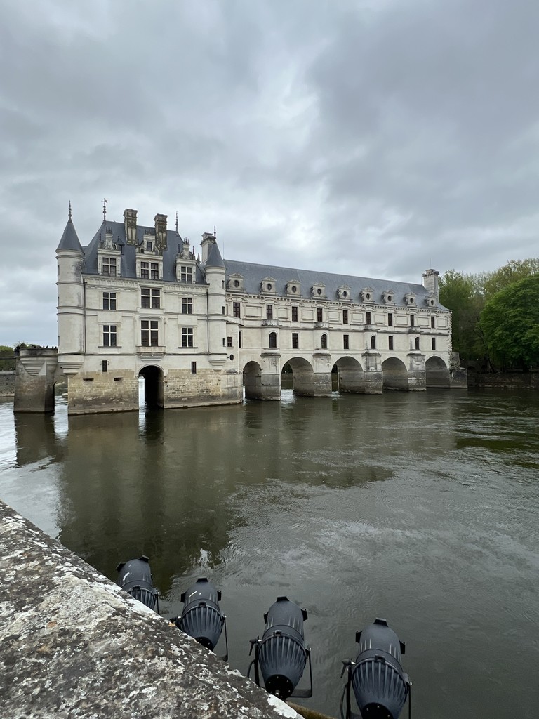 A building sits on a body of water with passageways built to pass through it.