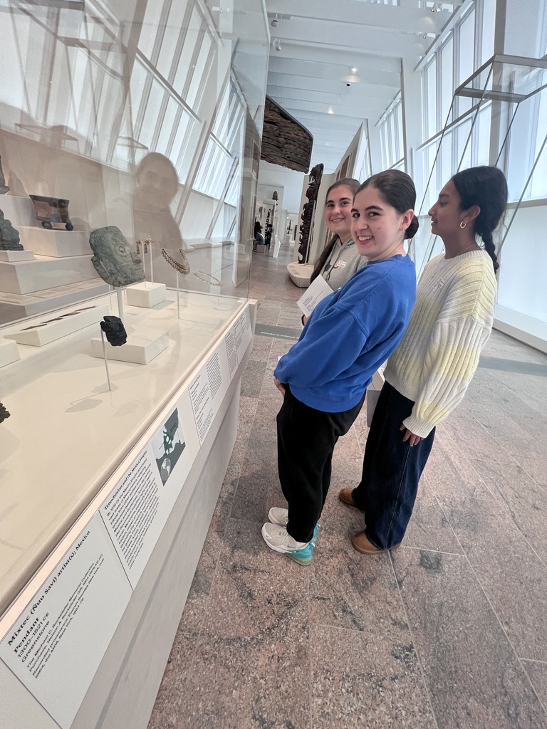 Students look at ancient artifacts.