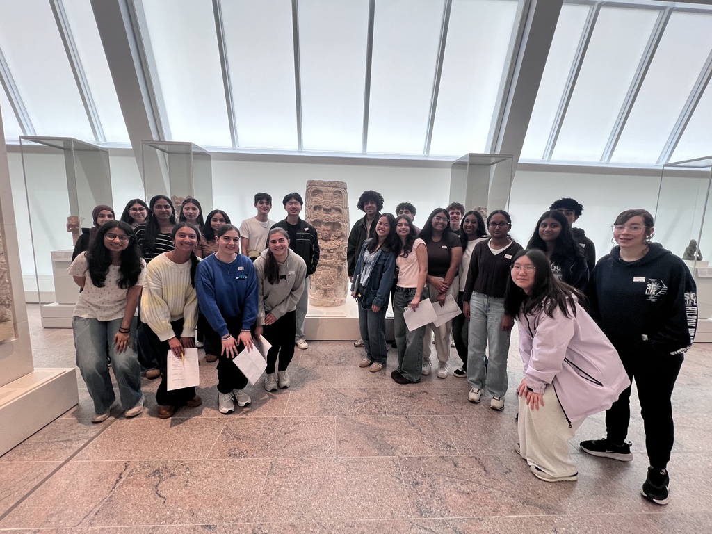 A group of students pose inside the Met museum in NYC.