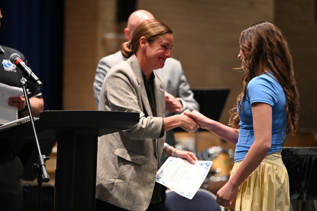 SMS P.E. Teachers hand award to student